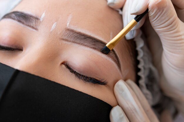 Beautician doing a microblading treatment on a client's eyebrows