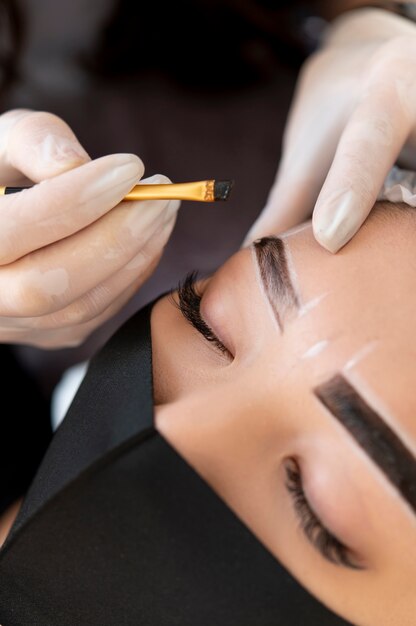 Beautician doing a microblading treatment on a client's eyebrows