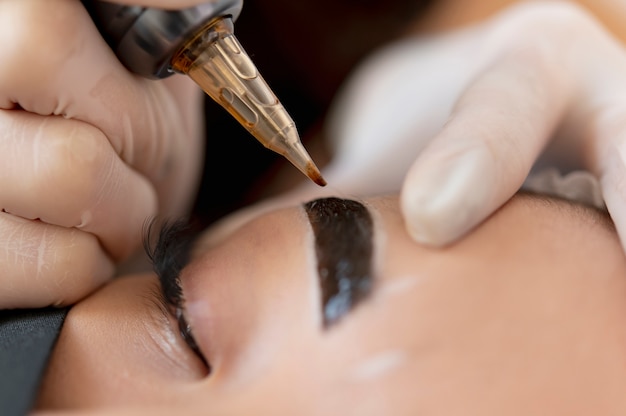 Beautician doing a microblading treatment on a client's eyebrows