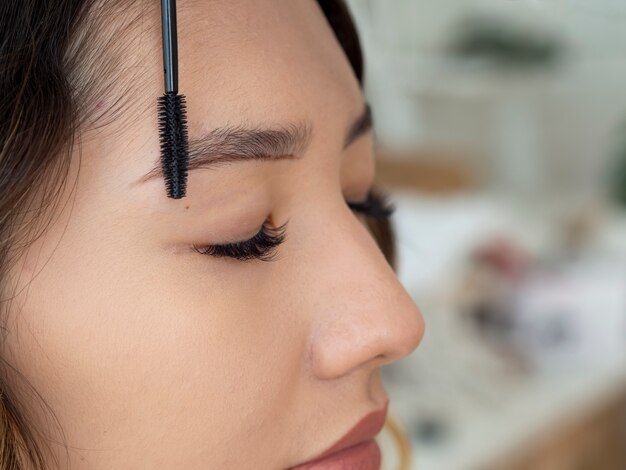 Foto gratuita estetista che esegue un trattamento di microblading sulle sopracciglia di una cliente