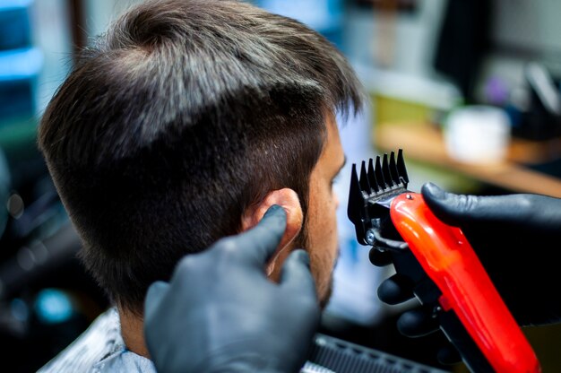 Beautician holding ear for haircut