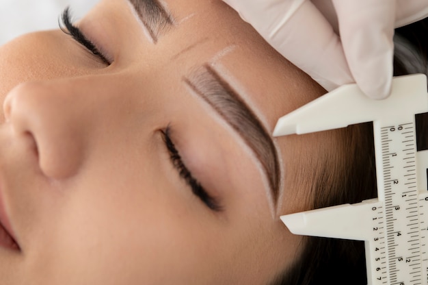 Free photo beautician working on a client's eyebrows