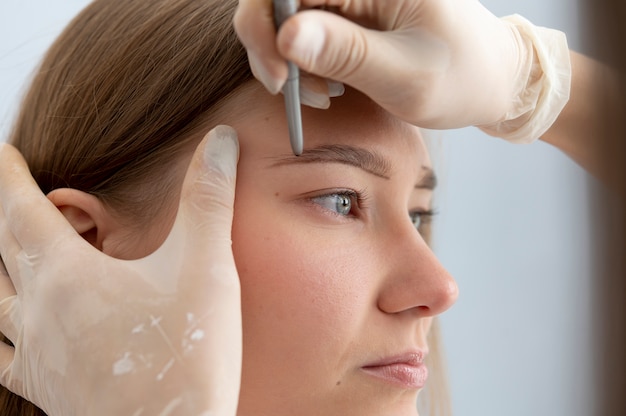 Free photo beautician working on a client's eyebrows