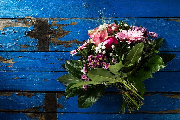 Beautifu pastel colors bouquet on blue rustic old table. Top View.