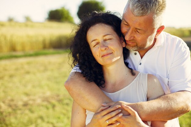 Beautiful adult couple spend time in a summer field