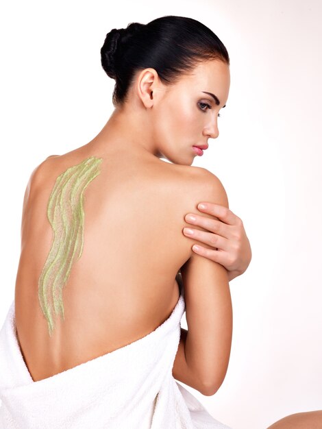 Free photo beautiful adult woman cares about skin of body using cosmetic scrub on the back