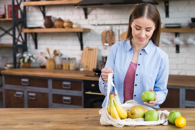 Bella donna adulta che controlla frutti organici