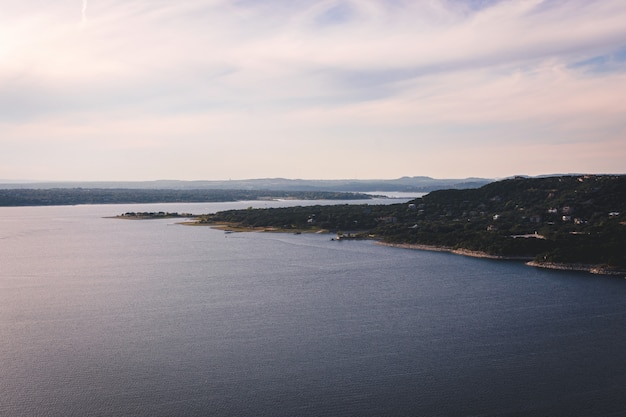 Beautiful aerial shot of a lake with a green field on the side