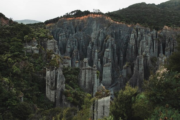 Beautiful aerial shot of rocks formation between forest on a hill