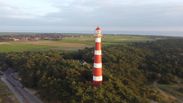 네덜란드 아멜란드(Ameland)의 무성한 나무로 둘러싸인 보른리프 등대(Bornrif Lighthouse)의 아름다운 공중 전망