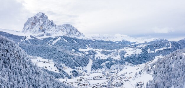 Beautiful aerial view of a ski resort and a village in a mountains landscape, in the Alps