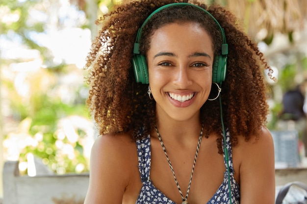 Beautiful African-American woman in cafe with headphones