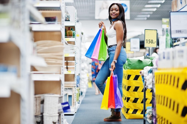 Bella donna afroamericana che tiene borse della spesa multicolori in un negozio