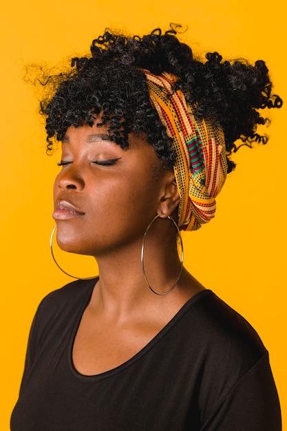 Beautiful African curly young woman on colored background