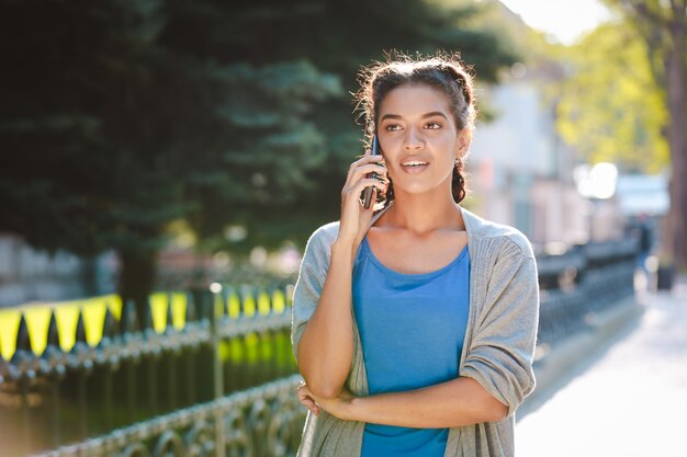 Beautiful african girl  talking on phone at nature background