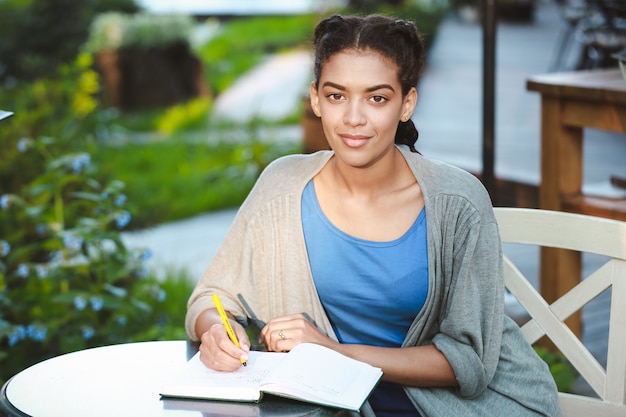 Foto gratuita bella ragazza africana scrivendo al notebook