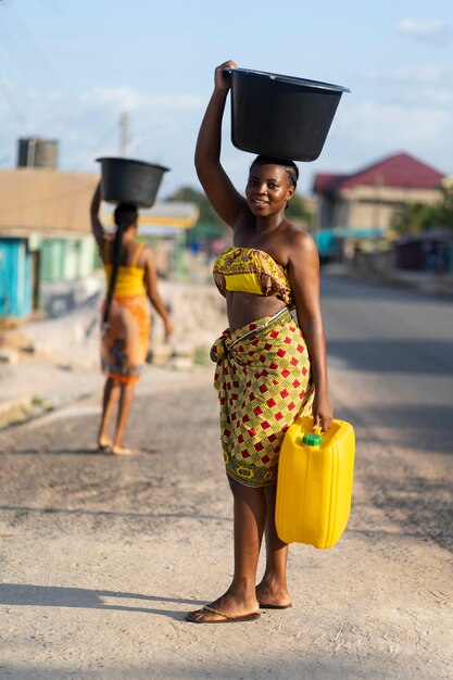 외부에서 물을 가져 오는 아름다운 아프리카 여성