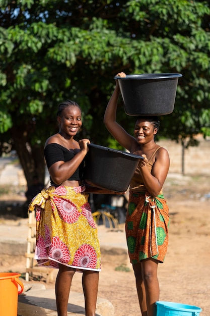 Free photo beautiful african women fetching water