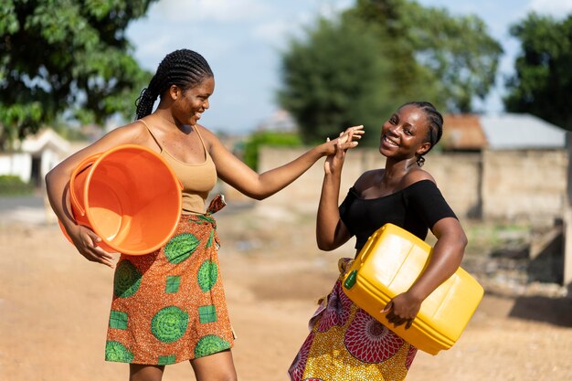 水を汲みながら楽しんでいる美しいアフリカの女性