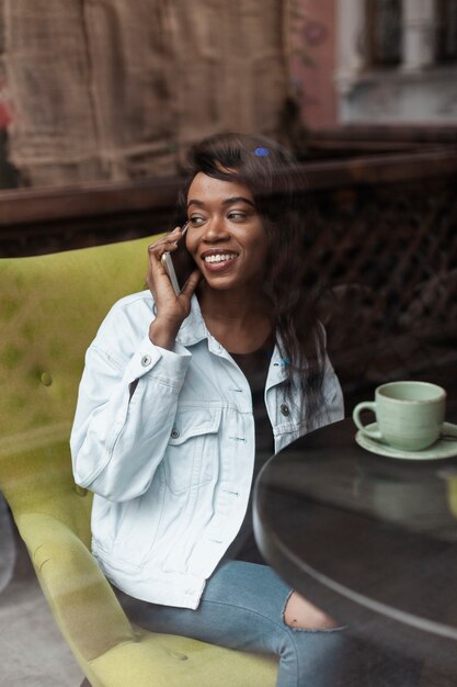 Bella donna afroamericana che parla sul telefono