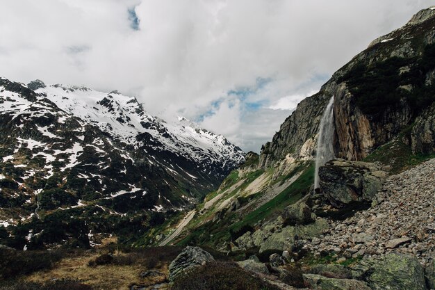 Beautiful Alpine landscape with waterfall in mountain at summer time