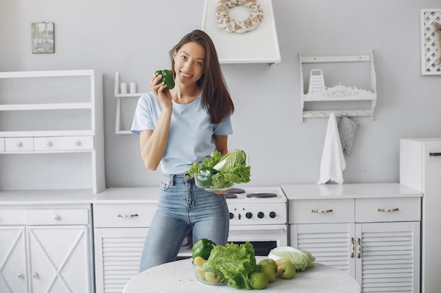 Бесплатное фото Красивая и спортивная девушка на кухне с овощами