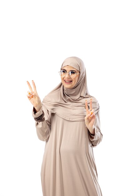 Красивая арабская женщина позирует в стильном хиджабе, изолированном на концепции моды