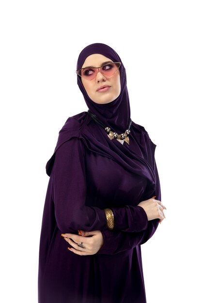 스튜디오 배경에 격리된 세련된 히잡을 입고 포즈를 취하는 아름다운 아랍 여성. 패션 컨셉