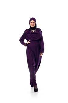 Beautiful arab woman posing in stylish hijab isolated on studio wall