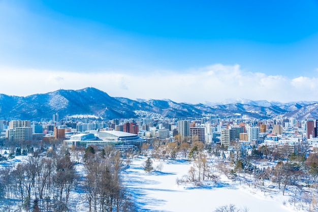 Foto gratuita bella costruzione di architettura con il paesaggio della montagna nella città hokkaido giappone di sapporo di stagione invernale