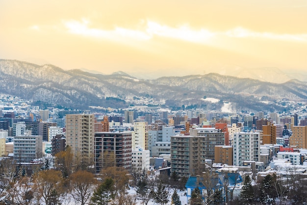 Free photo beautiful architecture building with mountain landscape in winter season at sunset time