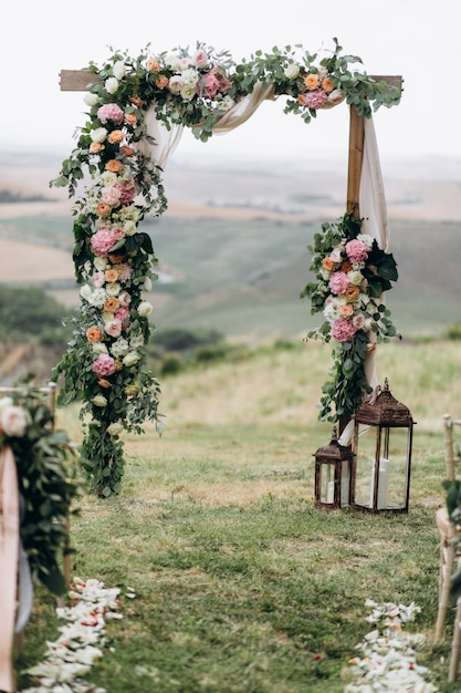 Beautiful archway decorated with floral composition outdoors