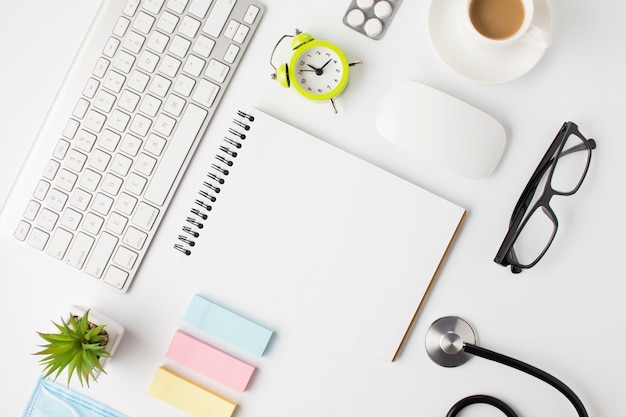 Beautiful arrangement of clinic desk with coffee cup and alarm clock