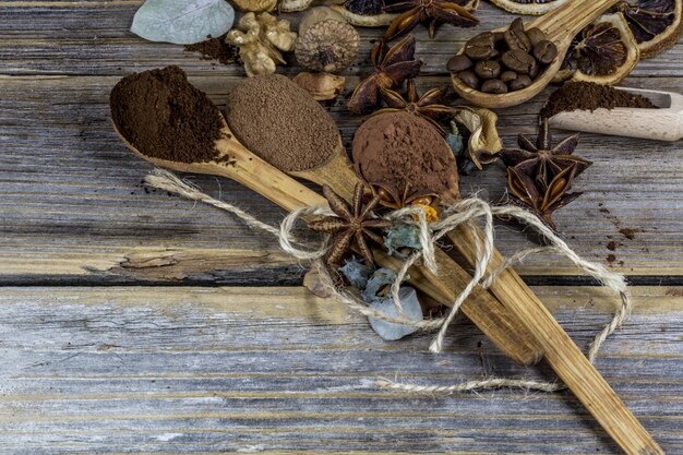 A beautiful arrangement of dried lemons, cinnamon, coffee on wooden spoons on wood