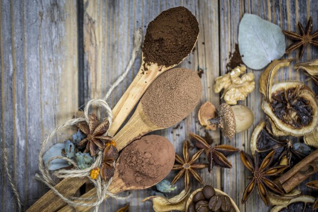 A beautiful arrangement of dried lemons, cinnamon, coffee on wooden spoons on wood