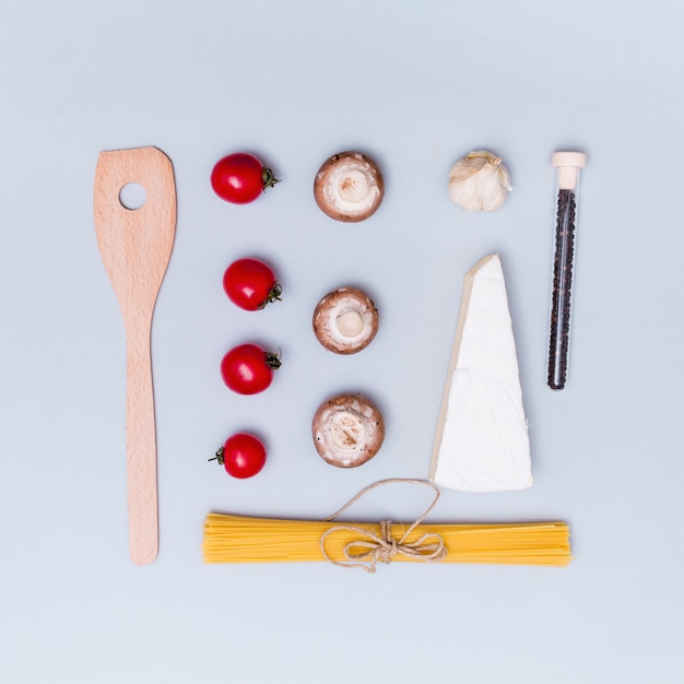 Beautiful arrangement of raw spaghetti pasta and it's ingredient with wooden spatula