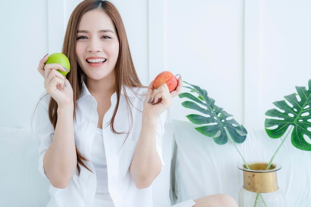 Красивая азиатская привлекательная женщина рука держит яблоко идеи здорового питания концепция портрет азиатской длинноволосой женщины