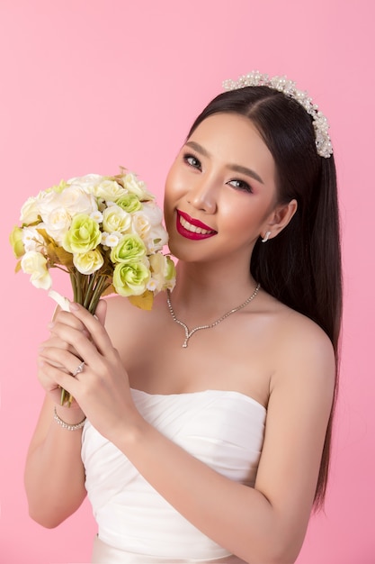 Красивый азиатский портрет невесты в розовой студии