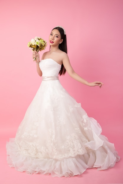 Free photo beautiful asian bride portrait in pink studio