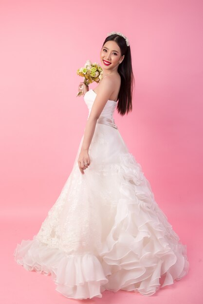 Красивый азиатский портрет невесты в розовой студии