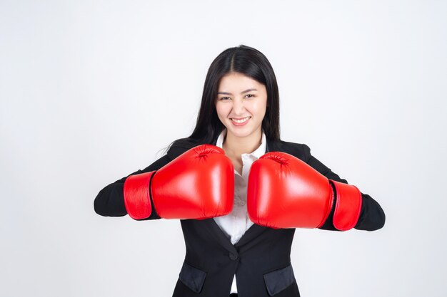 beautiful Asian business young woman  Wearing a boxing glove in hand and business suit