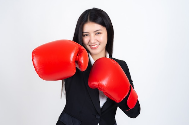 美しいアジアビジネス若い女性ボクシンググローブを手に持って、ビジネススーツ