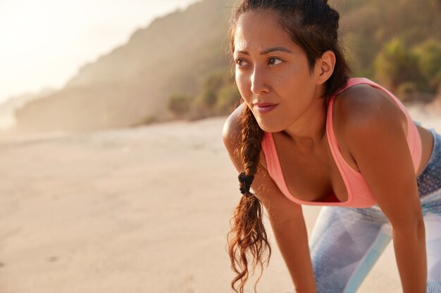 美しいアジアの女の子は、ジョギング運動の後に息をのむ