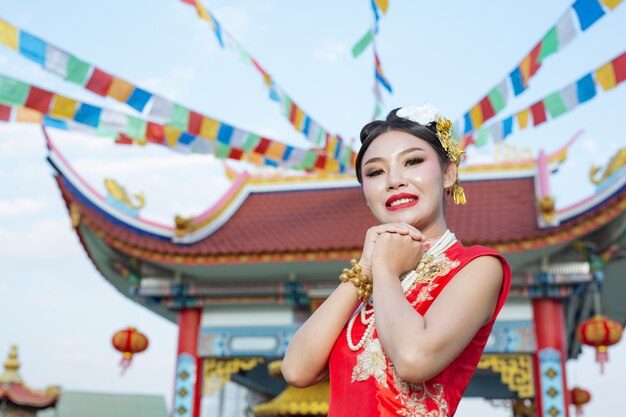빨간 예배를 입고 아름다운 아시아 소녀