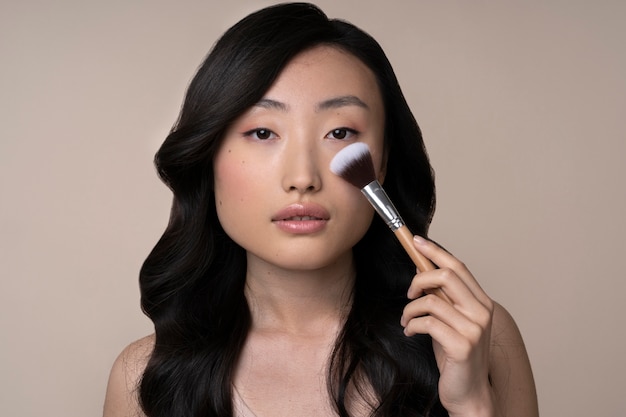 Beautiful asian woman applying makeup