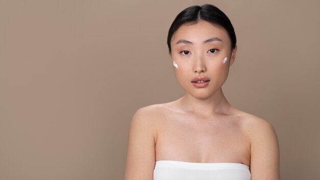 Beautiful asian woman applying skin treatment