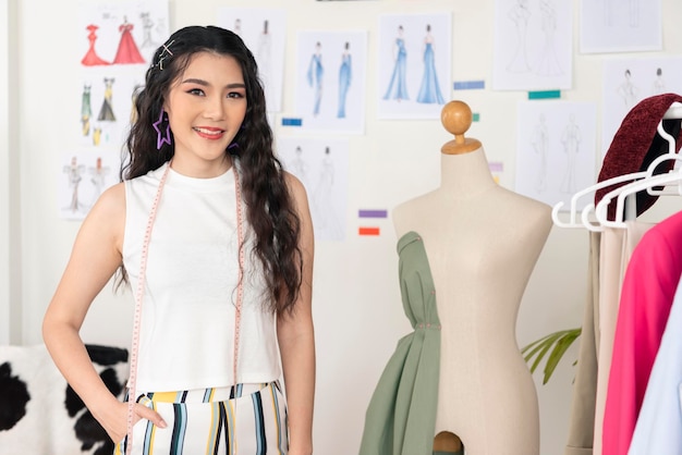 美しいアジアの女性のファッションデザイナーは、オフィススタジオ起業家smeビジネスコンセプトでポーズをとる