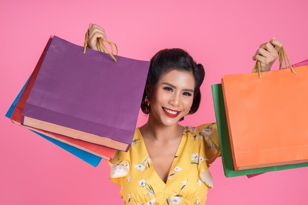 Beautiful asian woman holding colored shopping bags