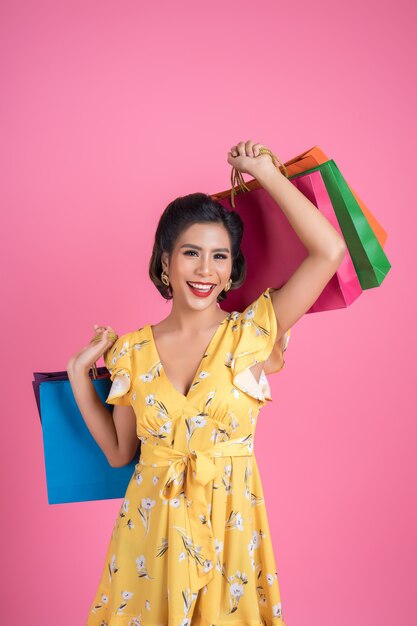 Beautiful asian woman holding colored shopping bags