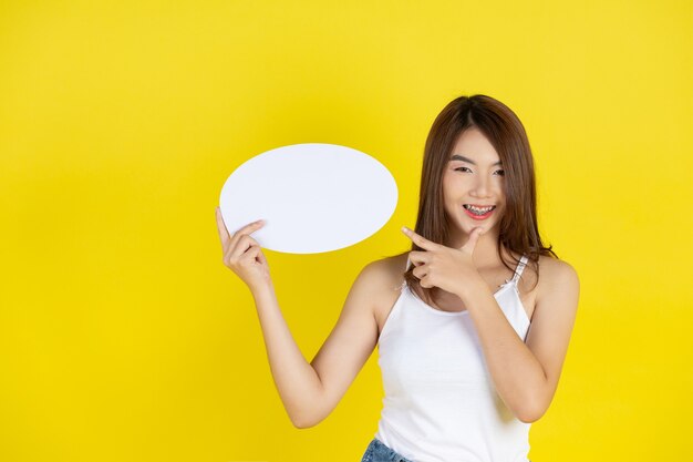 Beautiful asian woman holding and looking up to speech bubble with empty space